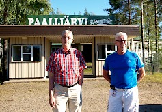 Maamiesseuran toiminnassa mukana oleva Paavo Pajala kertoo  Jorma Saarelalle (oik.), että etenkin 1970-luvulla lava kukoisti. Miehet myös katselevat mietteissään järvelle ja pähkäilevät noinkohan se Reetu on uimalla kiertänyt järven.