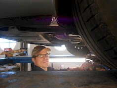 Autonasentaja Saku Ojala tarkastaa siltanosturilla Kenneth Kuuttisen omistaman Peugeotin alustan kuntoa. Tämäkin auto on tullut jo tutuksi muutamien vuosien mittaan.