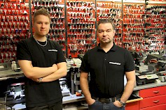 Henri ja Jani Saarimäen takana olevalla seinällä on runsaasti avaimia ja niiden aihioita. Yhteensä niitä yrityksessä on noin 2000 erilaista.