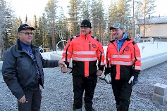 Pertti Niemi-Saari luovutti yrityksensä avaimet Mikko Vehniälle ja Kai Lehtiselle. Kuvassa takana pientalon perustus, johon pystytetään Kontio -hirsiomakotitalo. Kohteen urakoitsija on Alavuden Pelti ja Rakennus Oy.