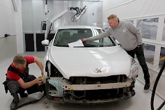 Jani Takala valmistelee autoa maalauskuntoon. Jari Rintamäki tarkistaa että auton korjausaika on aikataulussa..
