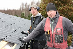 Kahden miehen porukka on hyvä koonpano kattotöihin, kun nostamisiin on käytössä kurottaja. Kuvassa Valtteri Rauhala ja Tapio Paavola asentavat omakotitalon uutta peltikattoa ja sadevesikouruja.