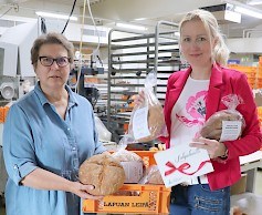 Seurakunnan tiedottaja Minna Ylimäki-Hemminki (oik.) ideoi seurakuntaleivän, jonka tulee saamaan Lapualle muuttaneet uudet seurakunnan jäsenet. Lapuan Leivän toimitusjohtaja Marianne Kuntsi iloitsee yhteistyöstä.