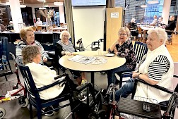 Kuvassa Saga Lakeudenlinnan iloinen naisporukka, jonka joukossa kukkapaitainen Tuula Saari vielä iloitsee ääneen että ”se on hienoa, kun johtajakin tulee meille päivittäin juttelemaan”.