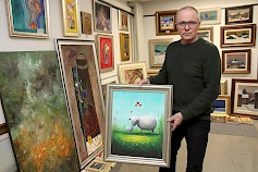 Markku Niemi esittelee Terry Laakson akryylityötä ”rakkaus”. Kuvassa taustalla useiden nimekkäiden kotimaisten taitelijoiden töitä.