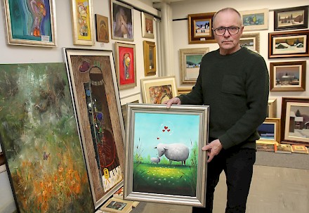 Markku Niemi esittelee Terry Laakson akryylityötä ”rakkaus”. Kuvassa taustalla useiden nimekkäiden kotimaisten taitelijoiden töitä.