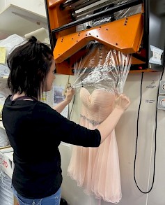 Juhla-asut pakataan Seinäjoen Pika-Pesussa huolellisesti. Työn touhussa Marjukka.