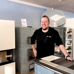 Henri Syrjälä Seinäjoen myymälässä, taustanaan upeita Tulikivitakkoja.