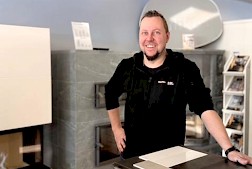 Henri Syrjälä Seinäjoen myymälässä, taustanaan upeita Tulikivitakkoja.