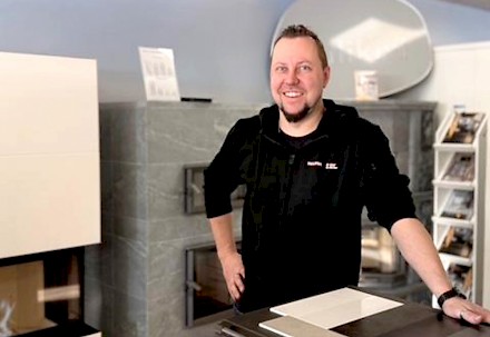 Henri Syrjälä Seinäjoen myymälässä, taustanaan upeita Tulikivitakkoja.