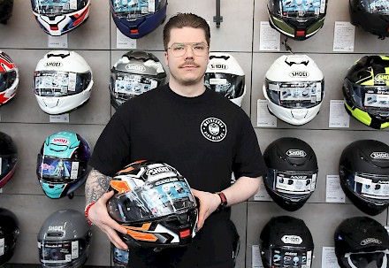 Nico Tarhanen esittelee Shoei Neotec 3 huippukypärää. Liikkeen telineissä on laaja valikoima erihintaisia ja erivärisiä kypäriä.