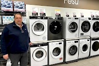 Kauppias Ville Paananen komean kodinkone rivistön äärellä.