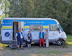 Kuuloauto vuosittaisella kierroksella Etelä-Pohjanmaan alueella. Kuvassa Rauno, Riitta, Sirkka-Liisa ja Kirsi kuuloauton vierellä Koskuella.