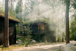 ”Pukuhuoneesta siirrytään ulkotilan kautta saunaan ja edelleen veden äärelle. Metsän tuoksut, viileä ilma, savu ja tummat puupinnat liittyvät osaksi harkittua rituaalia. Saunojen niukka valaistus ja suljettu mittakaava luovat suojan, josta avaudutaan takaisin metsään ja järvimaisemaan”, voittajan valinnut Timo Miettinen arvioi. Kuva: Kalle Kouhia.