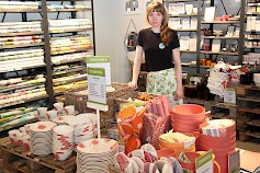 Pentik Outlet Tuurin toripöydät täyttyvät alennustuotteista, niinpä Elina Laukkonen toivottaa asiakkaat tervetulleiksi kesäiseen myymälään ja kesätorille.