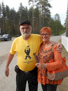 Jussi Vanha-Aho on kaapannut kainaloonsa Kauhajoen kaupunginhallituksen pj. Merja Kuusisen, joka toi iltaan kaupungin terveiset. Alavutelaisten lahjapuukon on valmistanut Pentti Kivimäki Kauhavalta. Kuva: ksk