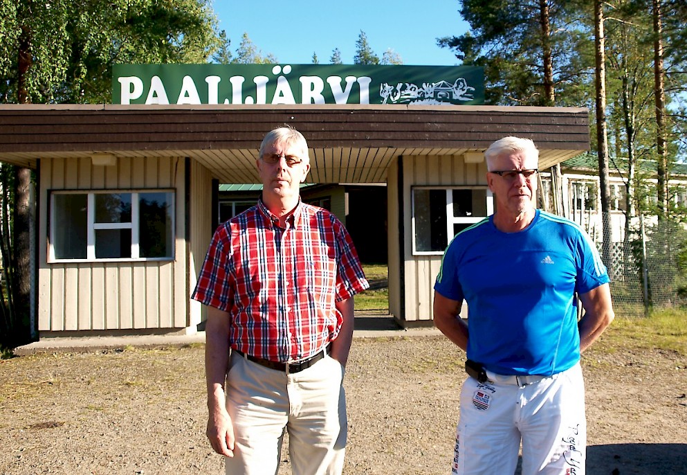 Maamiesseuran toiminnassa mukana oleva Paavo Pajala kertoo  Jorma Saarelalle (oik.), että etenkin 1970-luvulla lava kukoisti. Miehet myös katselevat mietteissään järvelle ja pähkäilevät noinkohan se Reetu on uimalla kiertänyt järven.