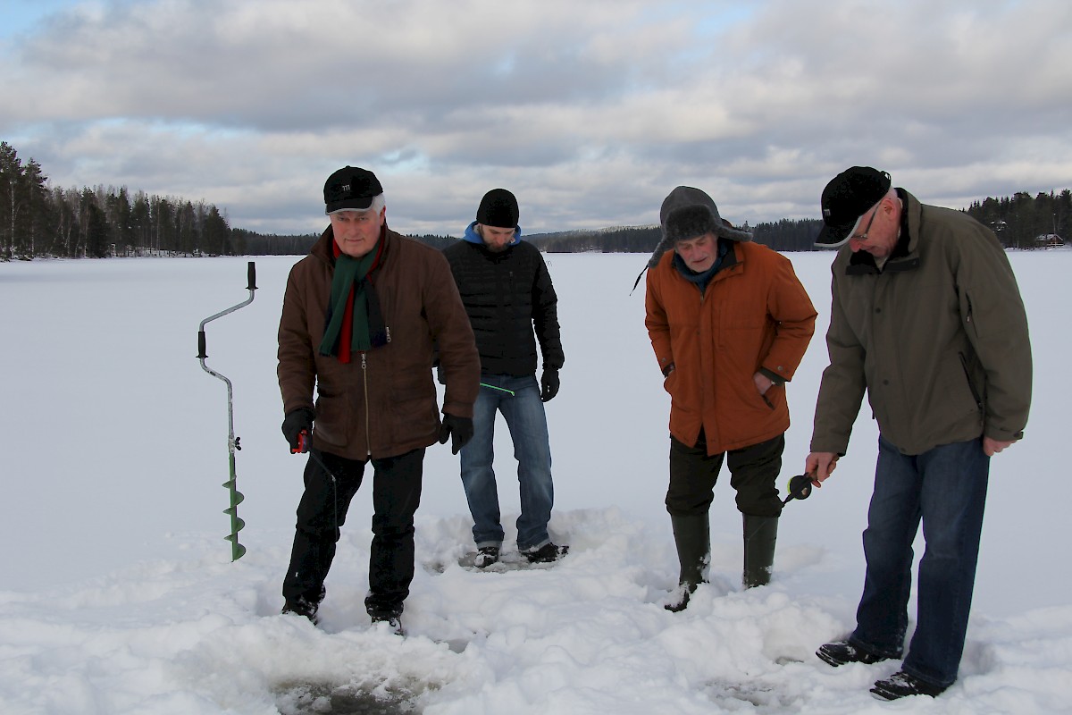 Tuomo Kivinen, Dini Mäntylä ja Kyösti Vehmaskoski koepilkillä Pohjoisjärven jäällä Iso Kala -pilkkikilpailun lähtöpaikan läheisyydessä. Erkki Kivinen (toinen oikealta) seuraa pilkkijöiden edesottamuksia.